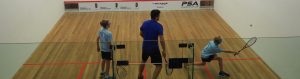 Man and boys playing squash